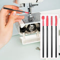 Sewing machine with a hand holding a red and black silicone brush, next to a set of three similar brushes.