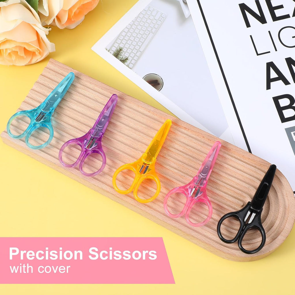 Set of colorful precision scissors on a wooden tray with a yellow background.